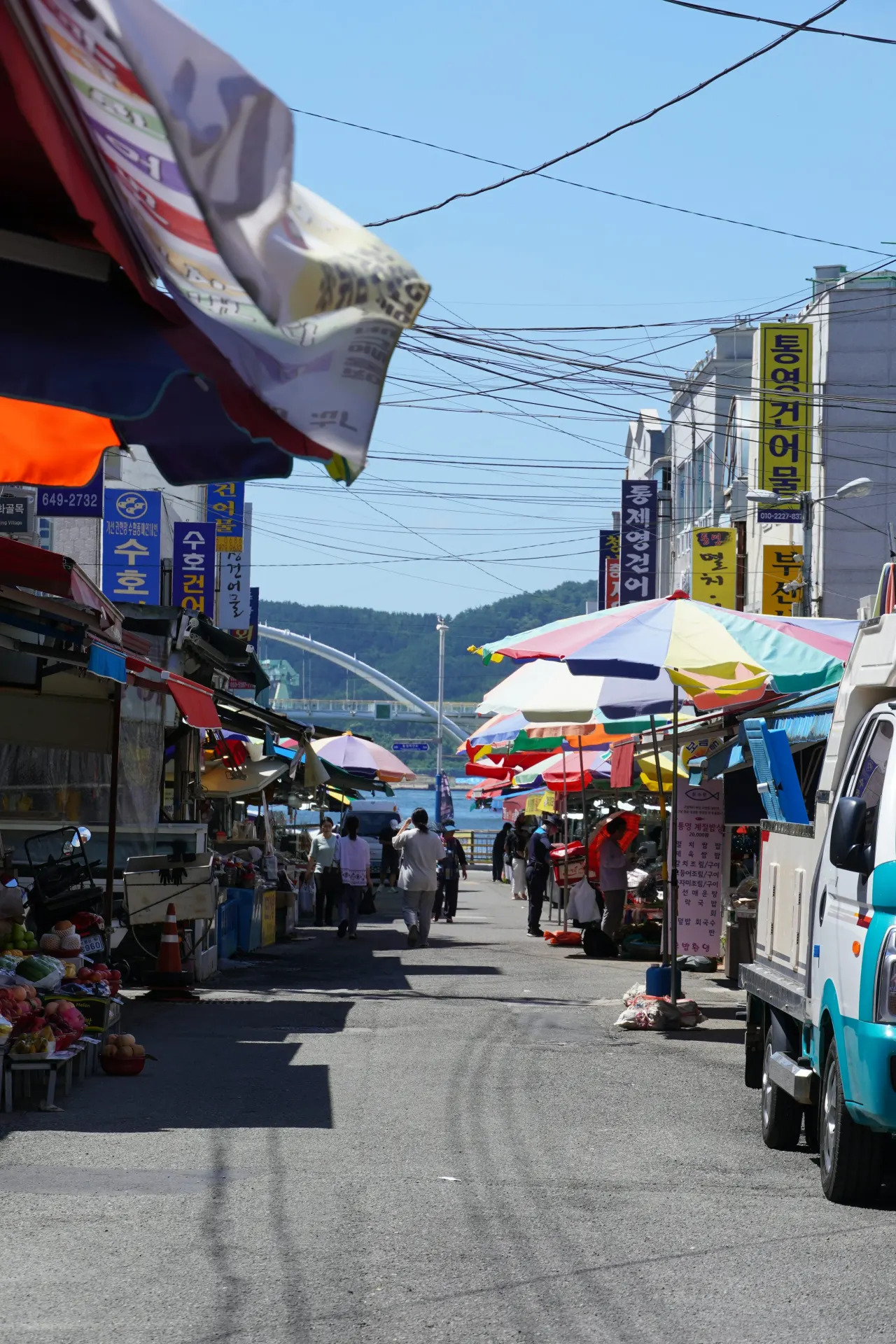 다채로운 우산과 사람들이 있는 야외 시장 가판대.
