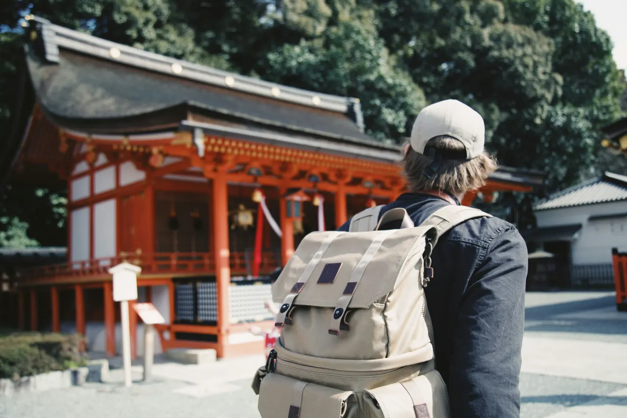 검은 상의와 배낭을 입고 주황색 구조 근처에 있는 남자